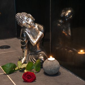 Amaryllis room detail Small bronze statuette of Asian deity, rose and scented candle