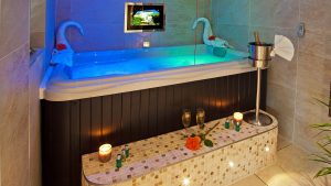 Hotel Bathroom beautifully lit with swan necked towel rolls champagne and complimentary wine
